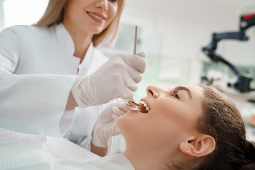 woman getting preventative dental care, flossing at the dentist